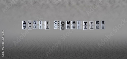 audit committee word or concept represented by black and white letter cubes on a grey horizon background stretching to infinity