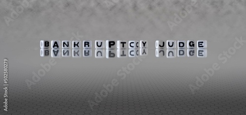 bankruptcy judge word or concept represented by black and white letter cubes on a grey horizon background stretching to infinity