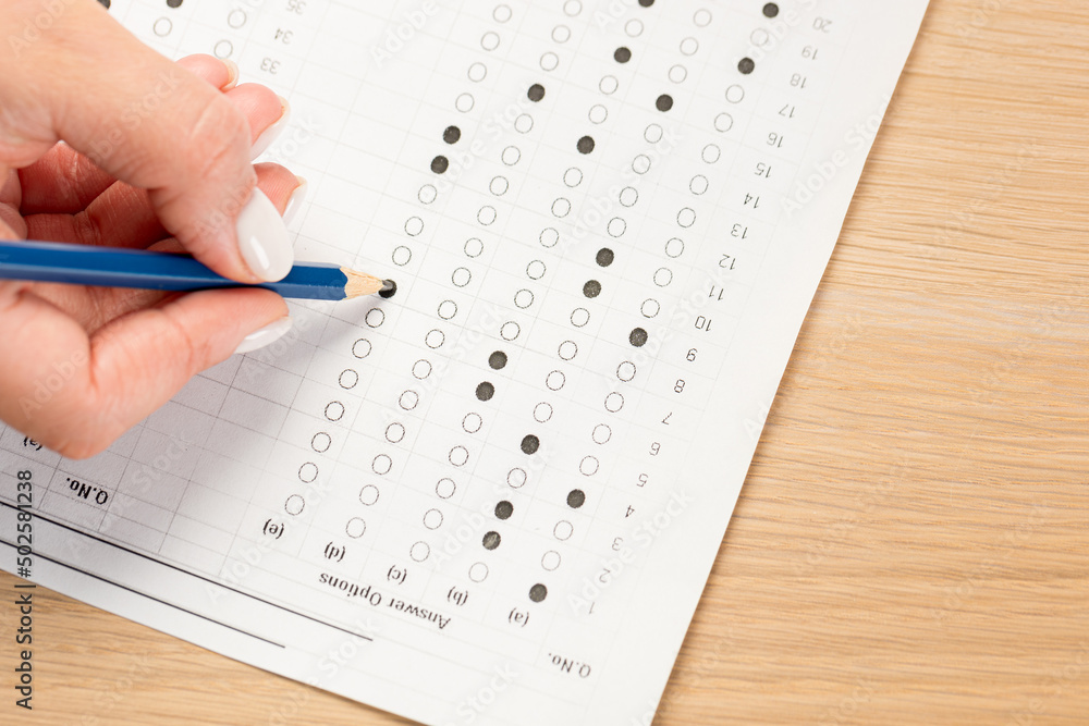 student hand testing in exercise and passing exam carbon paper computer sheet with pencil in school test room, education concept student hand testing in exercise and passing exam carbon paper computer sheet with pencil in school test room, education concept