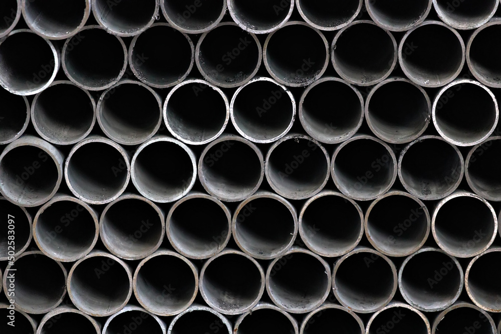 Maetallic pipes of the same diameter are neatly stacked. View of pipes from the front. Background for the supplier of metal products. Maetallic pipes of the same diameter are neatly stacked. View of pipes from the front. Background for the supplier of metal products.