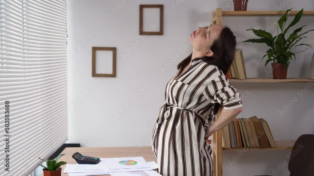 self back massage of a pregnant woman working in the office