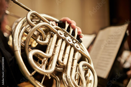 Close-up of a hand playing the horn at a concert photo