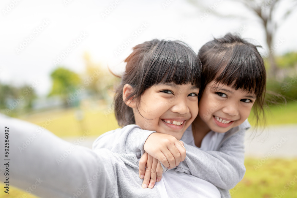 Happy Asian child takes a selfie in the park. Happy Asian child takes a selfie in the park.