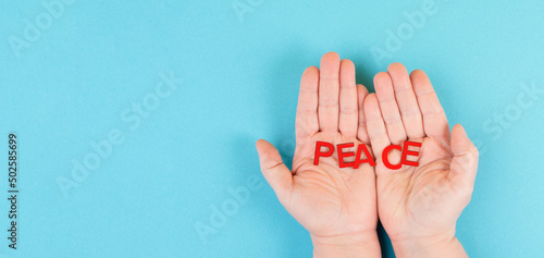 Holding the word peace in the hands, stop war, support Ukraine, living peaceful together 