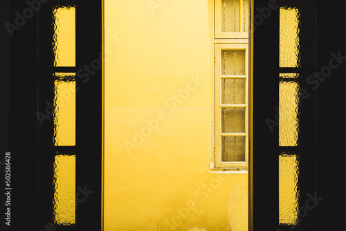 window in the yellow wall of the house