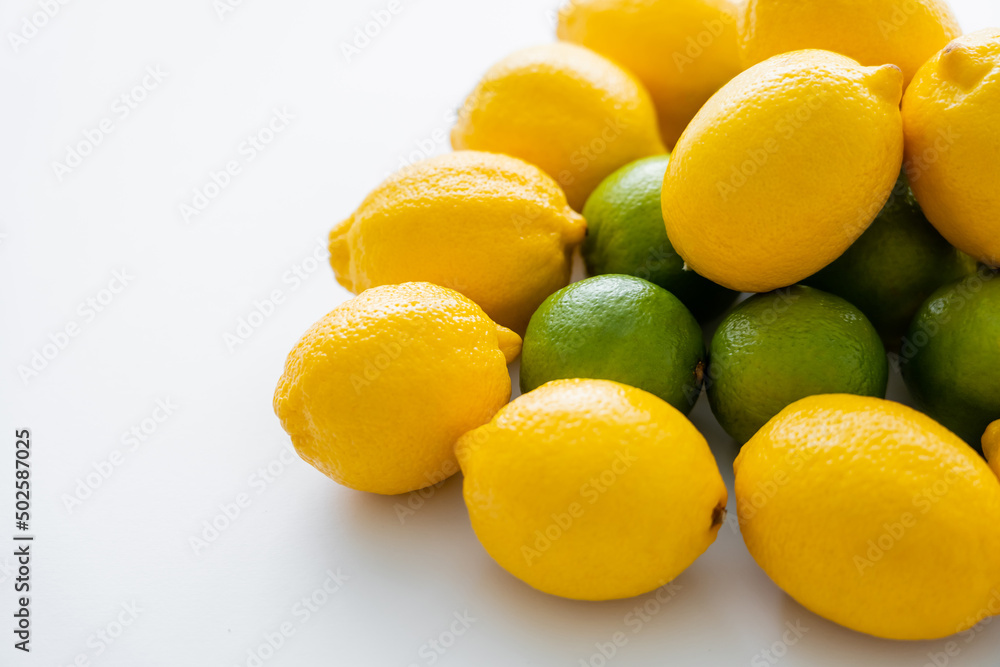 High angle view of organic lemons on limes on white background High angle view of organic lemons on limes on white background