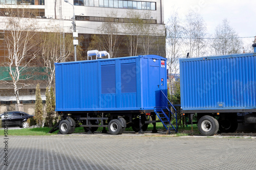 Industrial mobile diesel generator. Industrial diesel generator for an office building, connected to the electrical network by a cable.