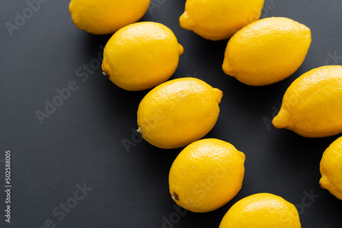 Flat lay of juicy and bright lemons on black background