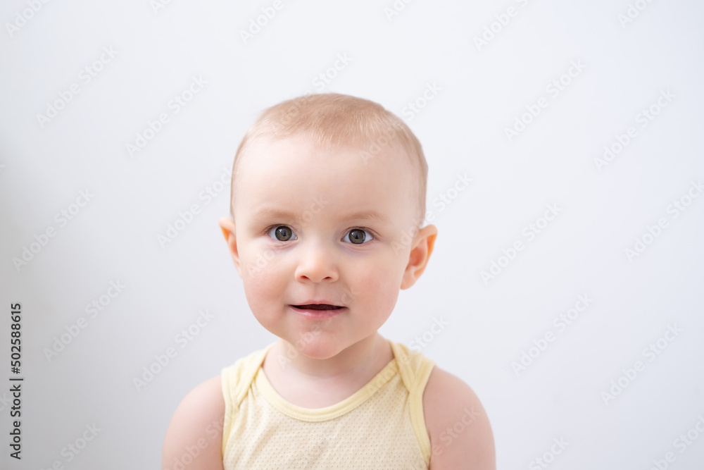 portrait of cute baby boy with brown eyes in yellow t-shirt on white background portrait of cute baby boy with brown eyes in yellow t-shirt on white background