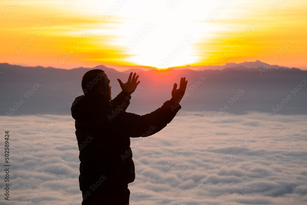 Man praying at sunrise