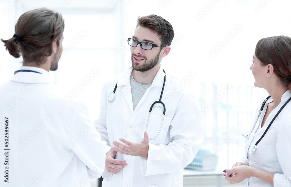 Medical staff discuss in a modern hospital room Medical staff discuss in a modern hospital room