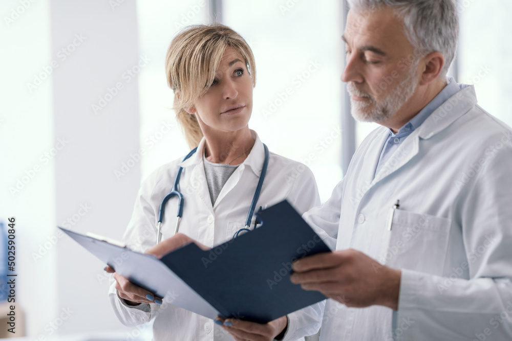Doctors checking medical records in the office Doctors checking medical records in the office