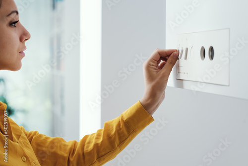 Woman checking settings on the boiler photo