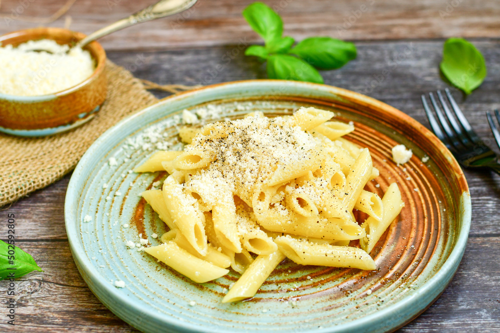 Home made italian Penne rigate Pasta with parmesan cheese,garlic and black pepper .Pasta cacio e pepe. Mediterranean food concept Home made italian Penne rigate Pasta with parmesan cheese,garlic and black pepper .Pasta cacio e pepe. Mediterranean food concept