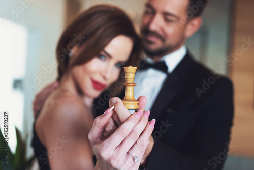 Happy young couple holding white chess queen photo