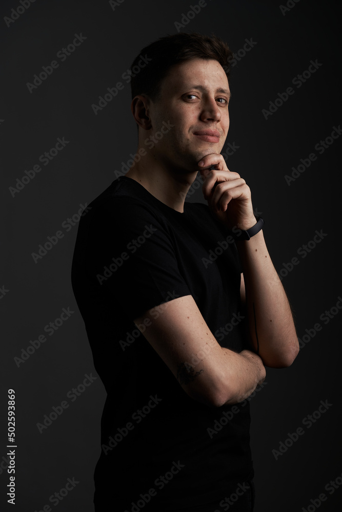 Portrait of a young, charismatic, handsome guy on a black background. Smiling and looking into the frame. Empty space for text. Portrait of a young, charismatic, handsome guy on a black background. Smiling and looking into the frame. Empty space for text.