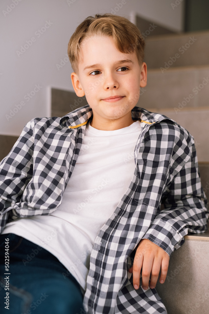 Stylish teenager guy smiling while posing for a beautiful photo while sitting on the steps. Stylish teenager guy smiling while posing for a beautiful photo while sitting on the steps.