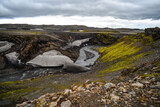 A snow bridge crossing a glacial river on the bleak volcanic landscape as seen on the hike from Skógafoss up to the Fimmvörðuháls hut and pass, south Iceland