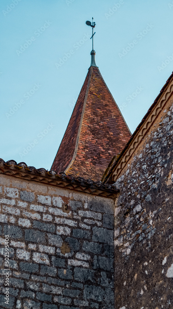 Long shot of church tower with a weathercock in small french village, south of france at Monpazier, near to the castles of Biron