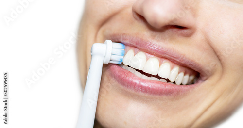 happy smiling woman brushing teeth with electric tooth brush. very close up mouth of excited girl, holding on teeth a electric toothbrush. dental care concept. natural healthy teeth 