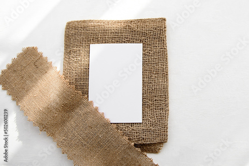 Fashionable stock white background and blank postcard blank on a linen napkin photo