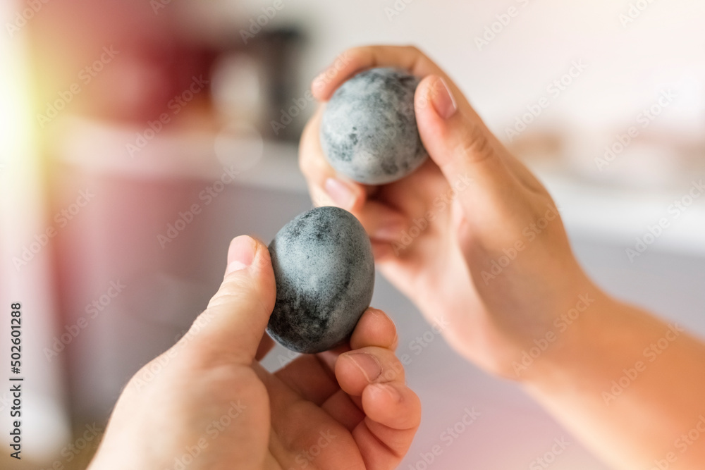 Hands break Easter eggs. Gray Easter eggs. Gaussian blurred background. Family tradition Hands break Easter eggs. Gray Easter eggs. Gaussian blurred background. Family tradition