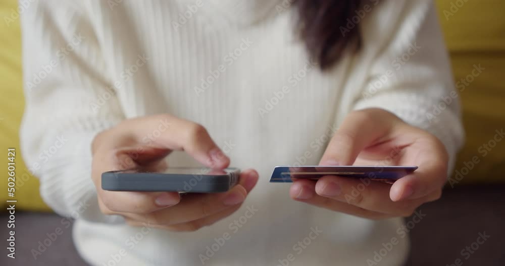 Close up of woman hand holding smartphone and mockup credit card.Female entering credit card code on website to distance payment or quick remote money transfer at home.Online shopping and lifestyle. Close up of woman hand holding smartphone and mockup credit card.Female entering credit card code on website to distance payment or quick remote money transfer at home.Online shopping and lifestyle.