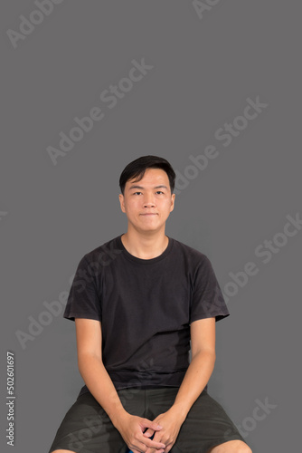 Portrait of a man Asian standing in black t-shirt and shorts. Isolated  on gray background with copy space and clipping path