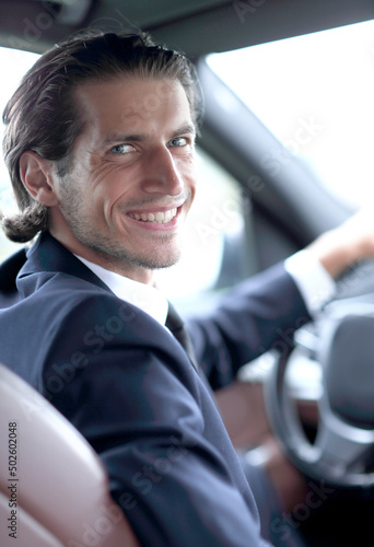 man sitting behind the wheel of a car