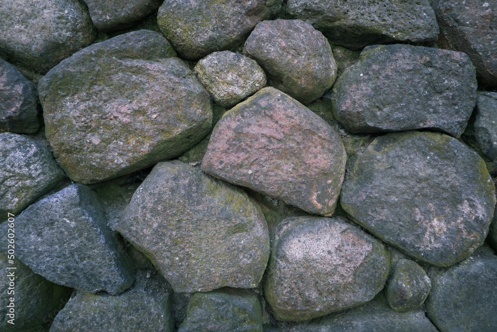 Retaining wall and pavement made of granite cobblestones in a European city. perspective street view Retaining wall and pavement made of granite cobblestones in a European city. perspective street view