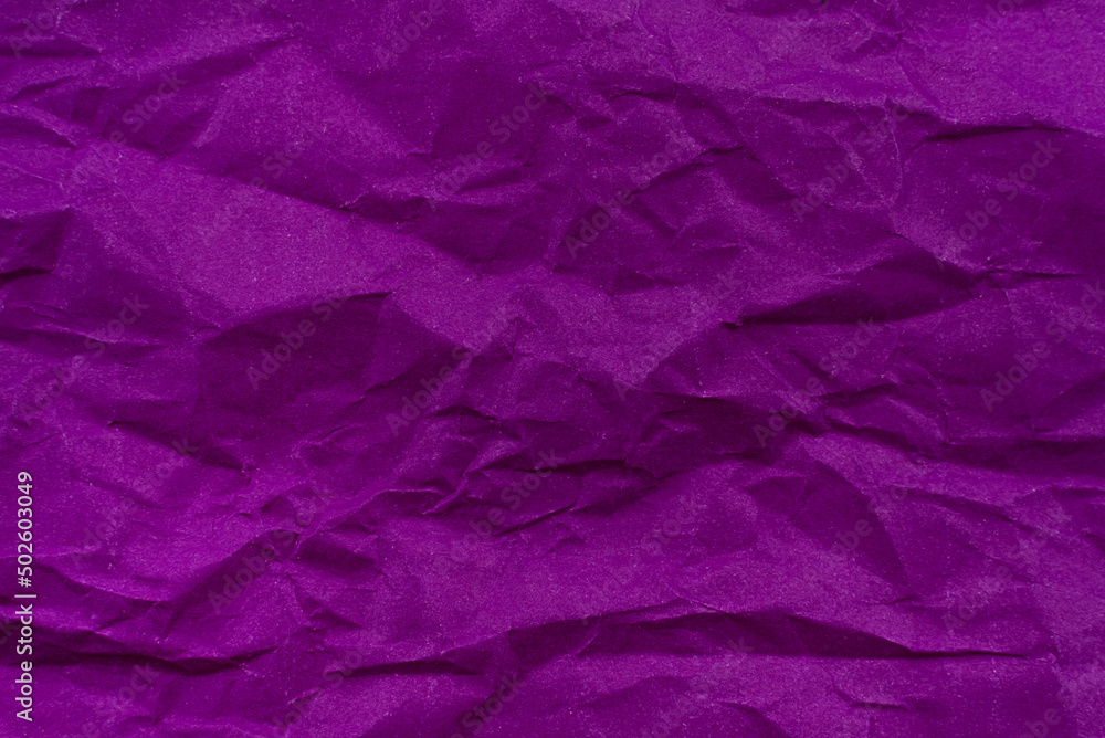 Background from crumpled paper in purple or lilac color. Paper texture with wrinkles and folds