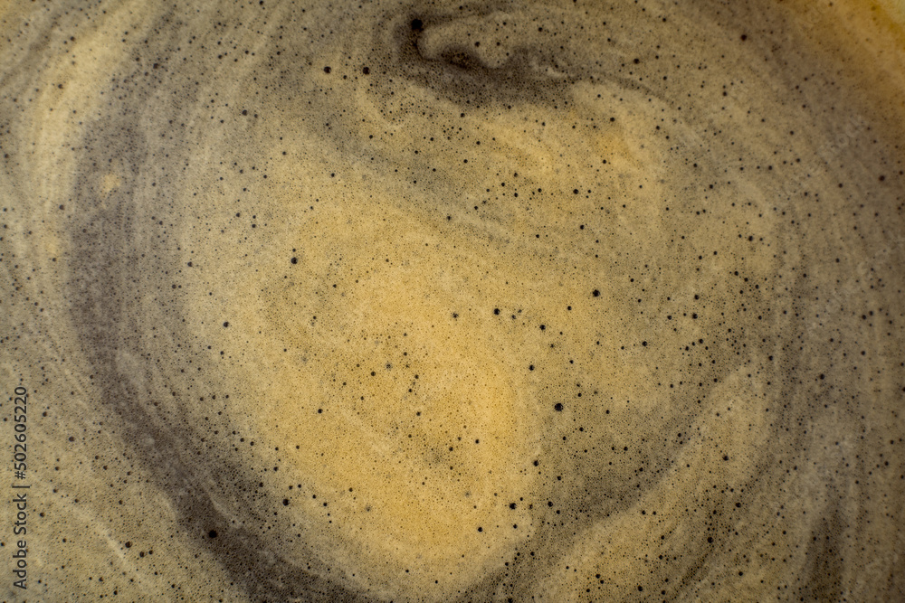 Coffee texture background. Strong espresso extreme dark coffee brown froth closeup