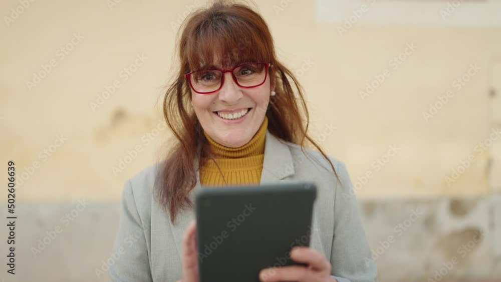 Middle age woman business executive using touchpad at street Middle age woman business executive using touchpad at street