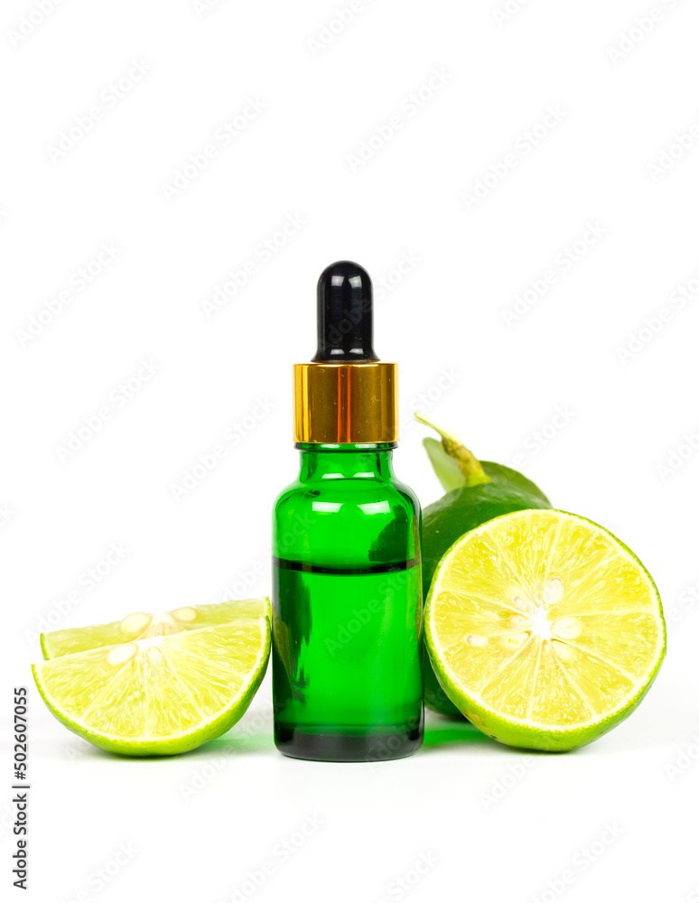 Lime essential oil in glass bottle and fresh lime fruits with green leaf isolated on white background. Use for spa, aromatherapy and body care concept. Lime essential oil in glass bottle and fresh lime fruits with green leaf isolated on white background. Use for spa, aromatherapy and body care concept.