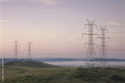 Electricity pylons in a field photo