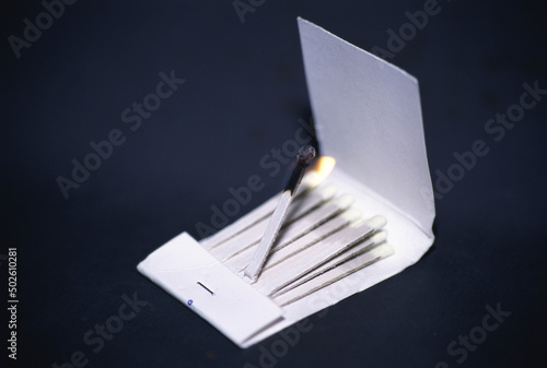 Matchbox with a lit match photo