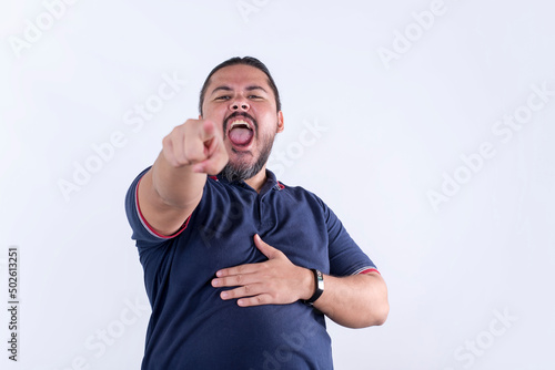 A rowdy man in his 30s, pointing and mocking someone relentlessly. A bully at the workplace. photo