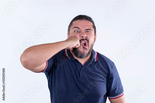 A man punches himself in the mouth after being frustrated in himself. Reaction after blundering. Isolated on a white background. photo