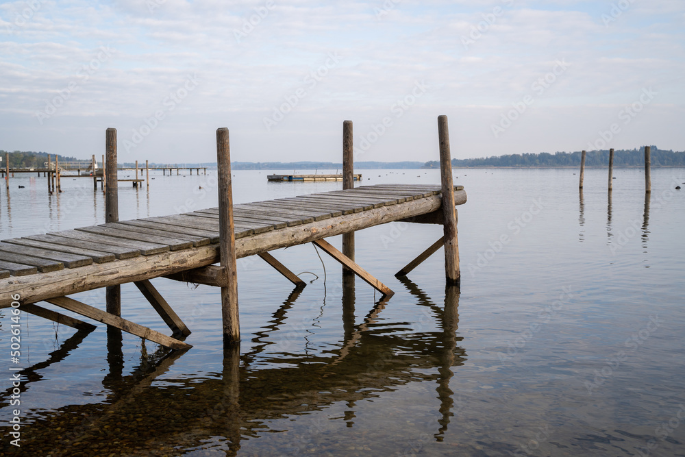 Wooden pier in the lake without boats in the morning