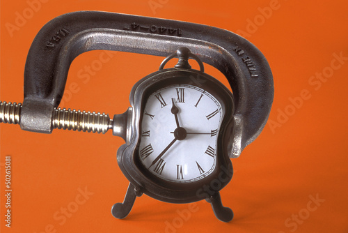 Close-up of an clamp squeezing an alarm clock photo