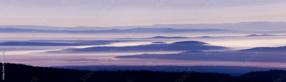 Silhouette of trees with a mountain range in the background, Crater Lake National Park, Oregon, USA