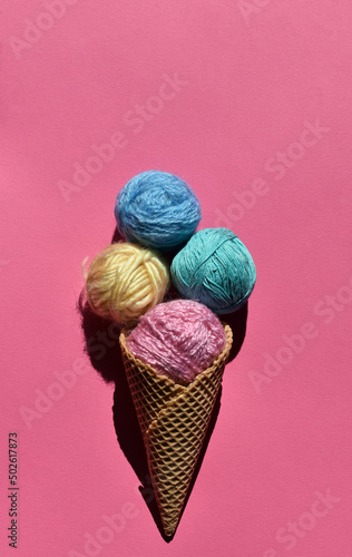 Vintage style concept with ice cream and balls of yarn on pink background. Flat lay. Minimal summer concept. Copy space.