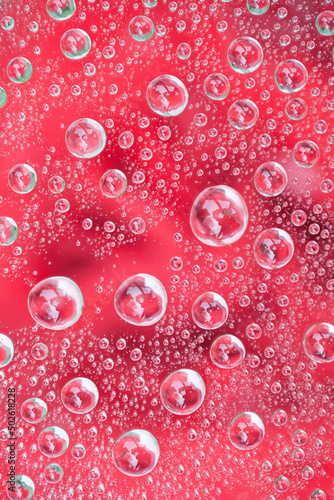 Water drops on glass - red rose in background photo