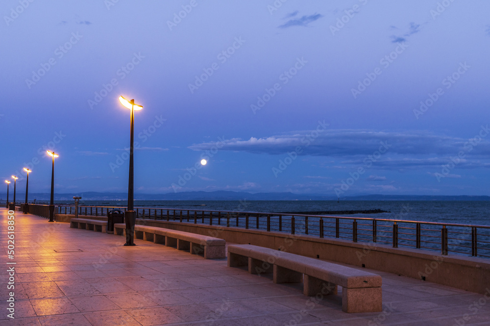 View to moonrise from seafront along Adriatic sea in Grado, Italy