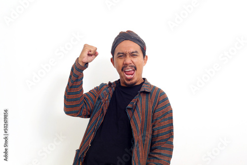 Successful asian man standing while clenching his hand. Isolated on white background