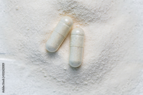 Fotografía collagen in tablets and powder on wooden white background.