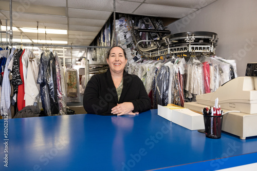 Portrait of a woman small business owner standing at counter of her dry cleaning shop. photo