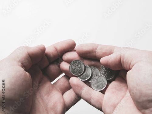 Coins in the palm of your hand. Poverty and depreciation. Minimum wage.