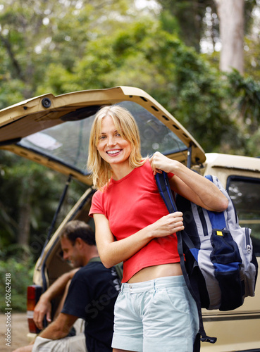 Adult hikers preparing themselves by their parked car in wilderness
