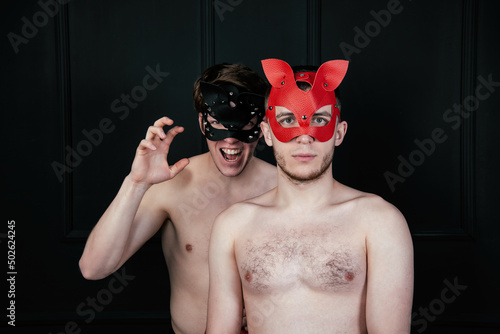 Bilde på lerret Portrait of a gay couple in red and black leather masks without a shirt